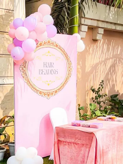 The charming hair beading station, set up outdoors. The pink decor and balloon accents create a fun and pretty corner for little princesses to get pampered.