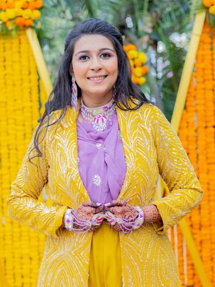 A portrait of the bride, looking happy and radiant. The soft makeup and floral jewelry are perfect for a fun-filled Haldi ceremony.