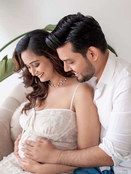 A loving couple's portrait from a studio maternity session, filled with smiles and affection.