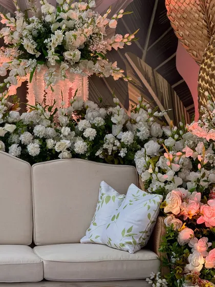 Another view of the elegant lounge seating, surrounded by a profusion of white flowers. The soft lighting creates a warm and inviting atmosphere.