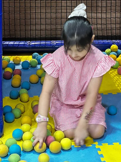Focused play in the ball pit, a simple activity that provides hours of fun for toddlers.