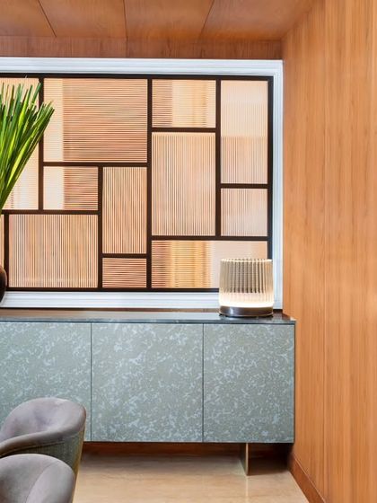 A close-up of the standout sideboard in the Magnolia dining room. Its unique texture and color create a stunning focal point against the warm wood-paneled walls. The geometric screen behind it adds another layer of pattern and interest.