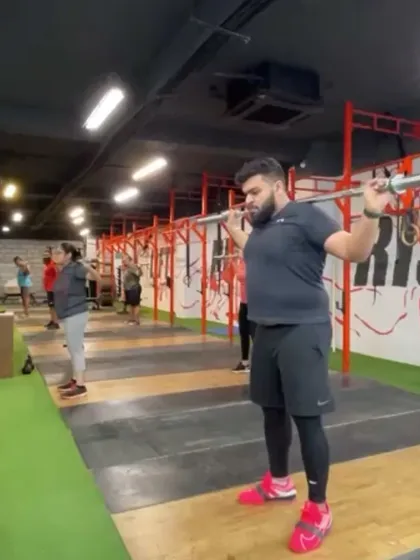 A client receives the bar in a power snatch, demonstrating a stable overhead position. This variation is great for lifters who are still developing the mobility for a full squat snatch.