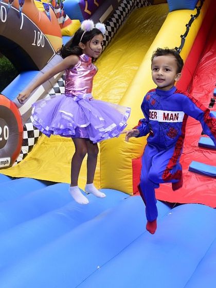 Pure joy and motion as two kids bounce on the inflatable race car slide. Capturing these moments of carefree fun is everything.