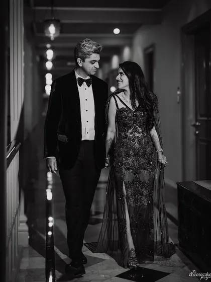A classic black and white portrait of the couple walking hand-in-hand before their cocktail party. Timeless elegance.