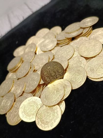 Another view of the Lakshmi coins, showing the Ashtalakshmi yantra embossed on them.