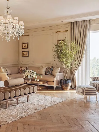 French elegance is captured in this bedroom through neutral tones, vintage accents, and natural textures. The striped armchair and ottoman provide a classic touch, while the herringbone floor adds warmth and character.