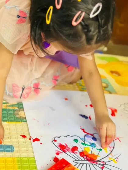 This is sensory art at its best! A child uses colorful, squishy water beads to decorate a butterfly, exploring different textures while making a beautiful piece of art.