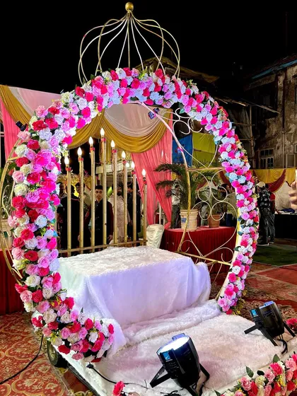 A closer look at the Crown Entry rental before the event. It features a large circular arch decorated with pink and white flowers, with candle-like lights in the background, ready for a grand reception.
