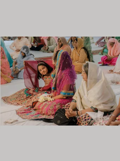 A candid moment during a Gurudwara ceremony, showing guests seated and observing the rituals, capturing the serene atmosphere.