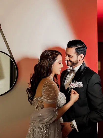 A sweet moment where the bride adjusts the groom's boutonnière, a small gesture of love and care.