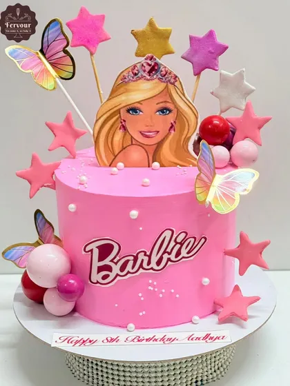 A pretty pink Barbie theme cake for an 8th birthday. This chocolate Oreo cake is decorated with stars, butterflies, and pink and red spheres for a fun, girly design.