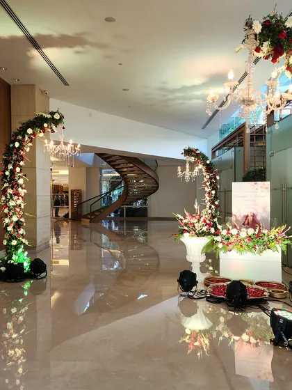 This stunning lobby transformation features curving floral arches accented with crystal chandeliers. The design guides guests through the space and creates multiple beautiful photo opportunities.