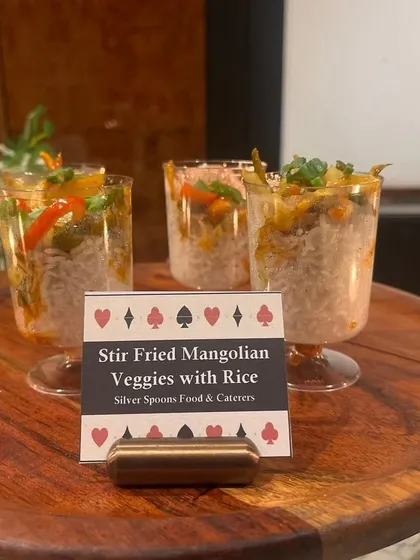 Stir-fried Mongolian vegetables with rice served in individual glasses. This Pan-Asian dish offers a flavorful and convenient option for guests at a festive gathering.