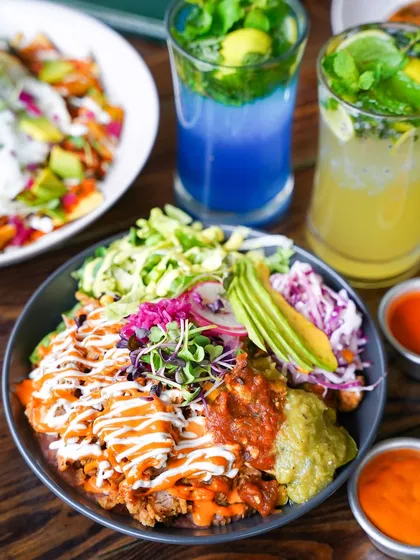 A colorful burrito bowl loaded with fresh ingredients like avocado, salsa, and sour cream. The bright, natural lighting makes the dish look healthy, fresh, and delicious.