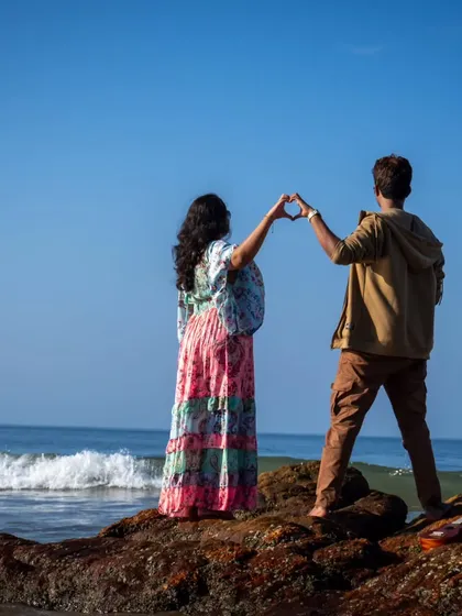 A classic heart shape made with their hands against the backdrop of the ocean. This is a fun and sweet pose that perfectly captures the love and excitement of a pre-wedding beach shoot.