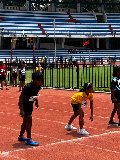 Young sprinters in their starting stance, learning the fundamentals of track and field.