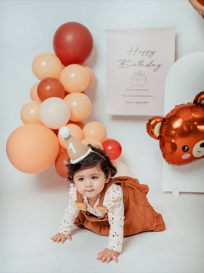 On your mark, get set, crawl. The birthday girl is on the move during her fun, balloon-filled teddy bear party photoshoot.