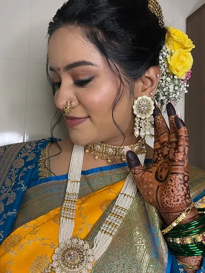 A close-up showing the intricate henna design and the beautiful floral hair accessories.