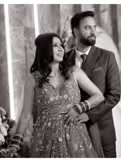 A classic black and white couple portrait. The couple looks away from the camera, creating a candid and thoughtful mood. The monochrome tones add a touch of timeless elegance.