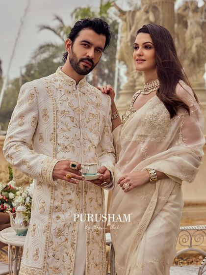Here, the couple redefines tradition with sophistication. The groom's sherwani, with its delicate gold embroidery, is a perfect match for the bride's elegant saree.