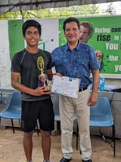 Rohit receiving his winner's trophy from a tournament official. A great moment for a young player.