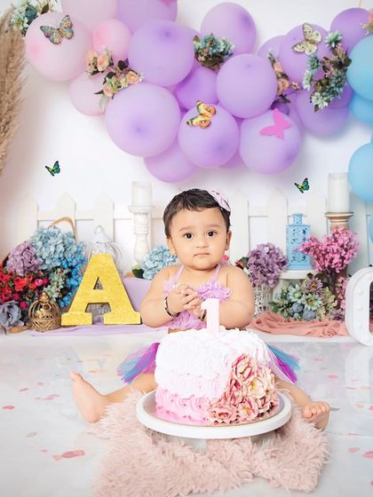 A moment of calm before the smash. This little butterfly is ready for her first taste of birthday cake in our beautifully decorated pastel-themed setup.