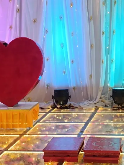 A close-up of the stage details for an engagement party. The large red heart prop and spotlights on the LED floor add a romantic touch to the celebration.