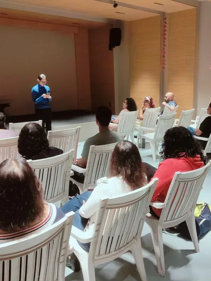 An audience seated in our auditorium, listening to a speaker during a literary event.