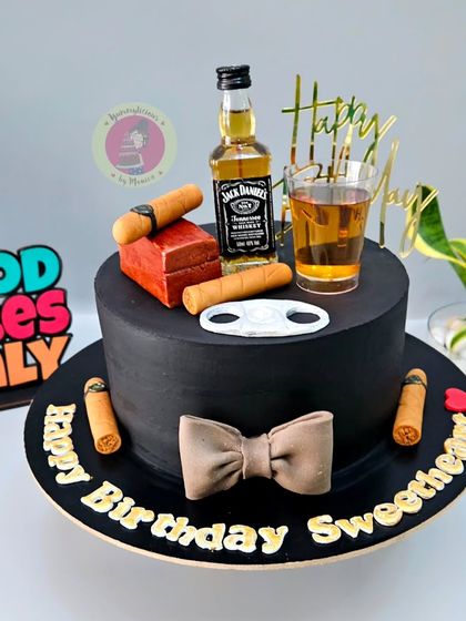 A sophisticated black hat-box cake for a whiskey lover, topped with a miniature Jack Daniel's bottle and fondant cigars.