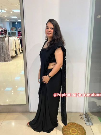 A side view of the black ready-to-wear saree, showing how the ruffles cascade down the edge for a modern and dramatic effect.