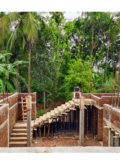 A residence in Kerala during the construction phase. This photo shows the formwork for a concrete staircase being built within the laterite brick structure, a common and durable local material.