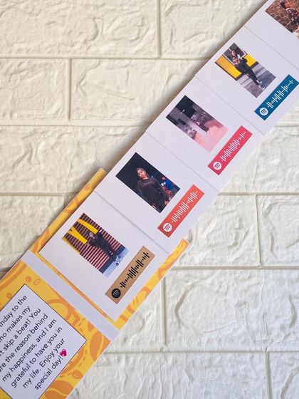 The slider card fully extended, revealing the series of five photos, each paired with a different song that tells your story.