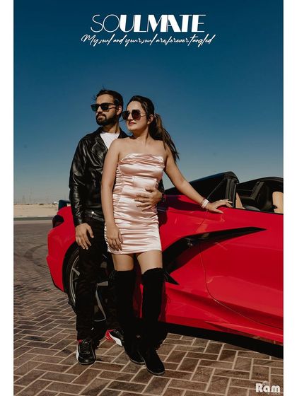 A chic and modern portrait of a couple posing with a red convertible in the Dubai desert. This image screams "soulmates" with a cool, fashion-magazine aesthetic.