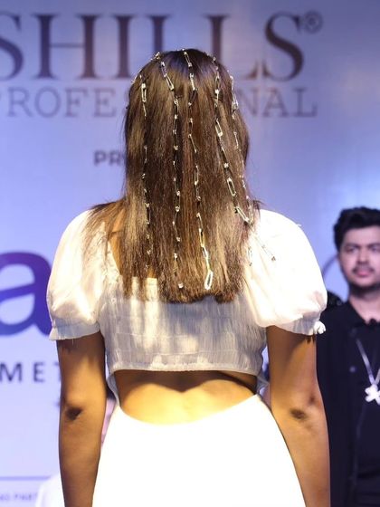 A creative runway look featuring hair chains woven into the style for a unique, high-fashion effect.