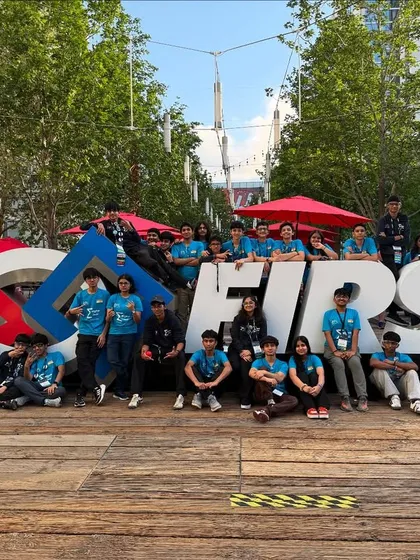 Team Sigma gathered around the FIRST sign. This photo symbolizes their presence on the global stage of robotics.