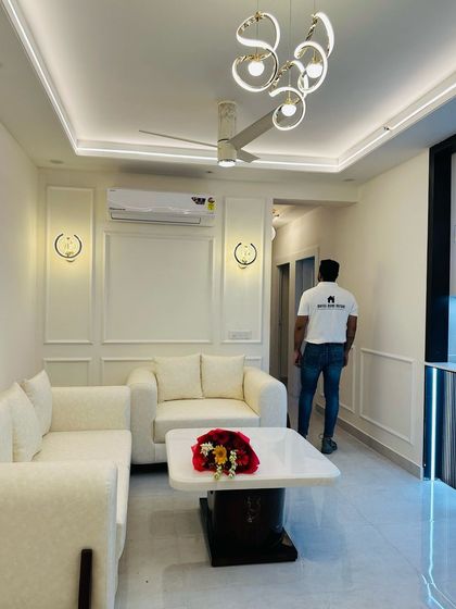 A full view of a completed living room at JM Florence, designed in a clean, all-white theme with modern furniture and lighting.