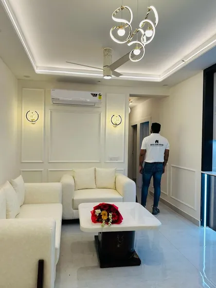 A full view of a completed living room at JM Florence, designed in a clean, all-white theme with modern furniture and lighting.