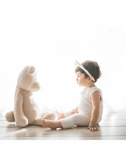 A quiet conversation between friends. This side profile shot of a baby and a teddy bear is simple, sweet, and full of innocence.