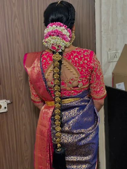 A full back view of the South Indian bridal hairstyle and the exquisite embroidery on the blouse. Every element is considered to create a picture-perfect look from every angle.