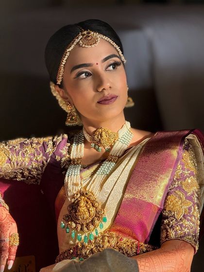 Another angle of this bride's look, showcasing the intricate details of her jewelry and the elegant, traditional hairstyle that completes her Muhurtham look.