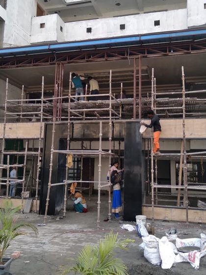 The exterior of the luxury housing tower foyer during the construction phase. This image shows the scale of the project and the raw structure before the facade and design elements are installed.