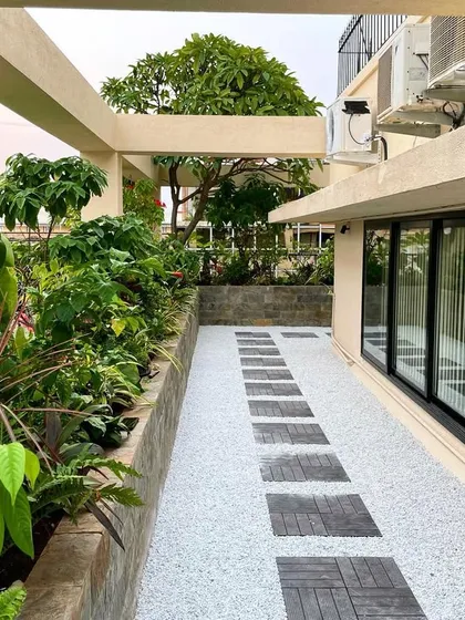 This angle shows the practical side of the corporate terrace design, with space for AC units neatly integrated without disrupting the aesthetic of the garden walkway and planters.