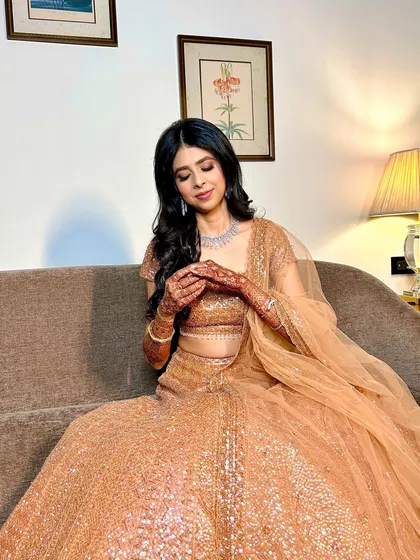 A candid moment showing the bride's henna. Her makeup looks soft and beautiful, even in a relaxed pose.