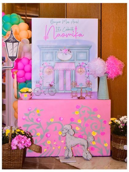 The welcome signage for the Parisian party, featuring a beautiful illustration of a French cafe, a poodle cutout, and floral details.