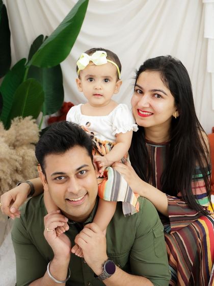 A playful family moment with the baby girl sitting on her father's shoulders. These photos capture the fun and joy of your family's personality.