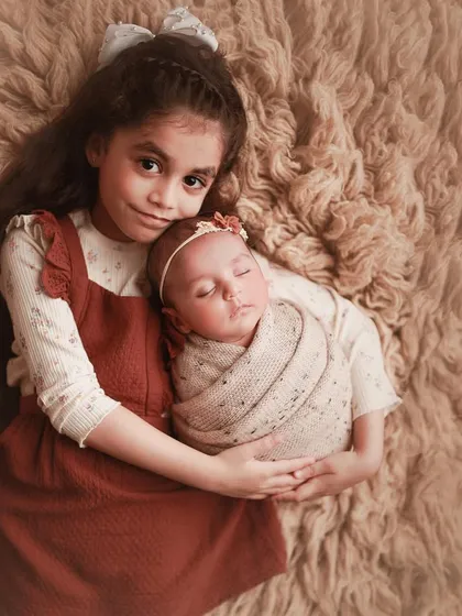 Welcoming a new baby is a special time for the whole family. I love capturing the gentle, loving bond between siblings, like this sweet moment of a big sister proudly holding her new best friend.