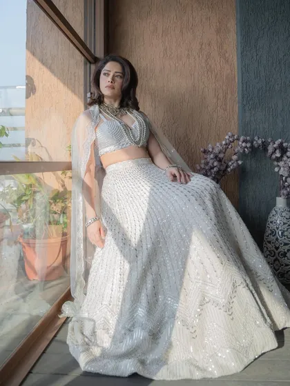 I styled Nushrratt Bharuccha in this ethereal ivory lehenga by Disha Patil for a wedding. The layered pearl necklaces add a touch of modern royalty, making it a standout look for a wedding guest.