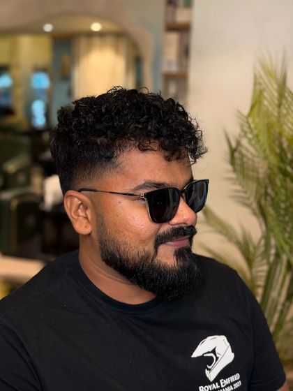 A good look for curls. This style combines a clean fade with textured curls on top for a sharp, modern finish.