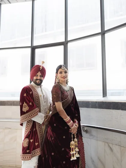 The most regal bride and groom. This couple portrait showcases the beauty of coordinated Punjabi wedding attire, with the bride looking stunning in a deep velvet lehenga.